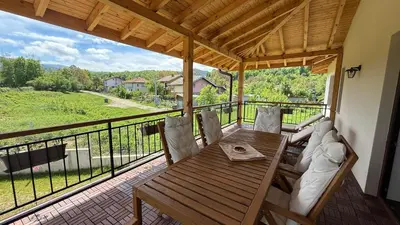 a porch with a wooden table and chairs and a view at Edelweiss Oreshak in Oreshak