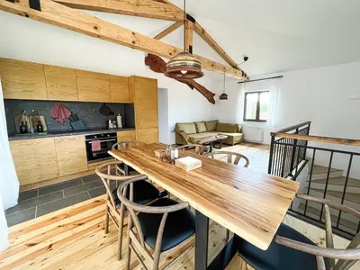 a kitchen and living room with a wooden table and chairs at Edelweiss Oreshak in Oreshak