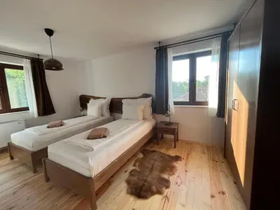 a bedroom with two beds and a rug on the floor at Edelweiss Oreshak in Oreshak