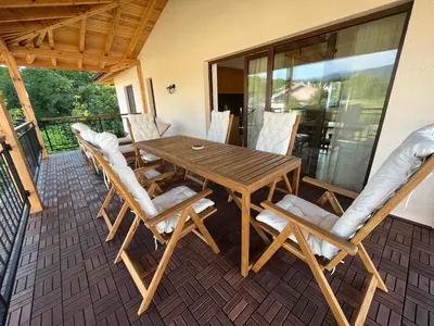 a wooden table and chairs on a patio at Edelweiss Oreshak in Oreshak