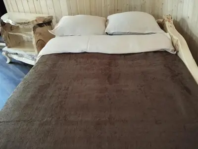 a bed with white sheets and pillows in a room at Приказната къщичка на Смърфовете in Krayni Dol