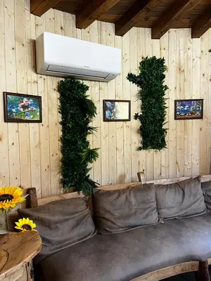 a living room with a couch and plants on the wall at Приказната къщичка на Смърфовете in Krayni Dol