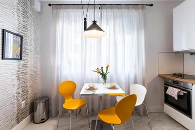a kitchen with a table and yellow chairs in a room at Aristocratic apartment with a parking spot in Sofia