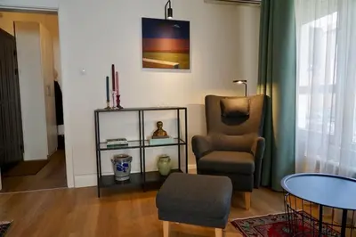 a living room with a chair and a table at Aristocratic apartment with a parking spot in Sofia