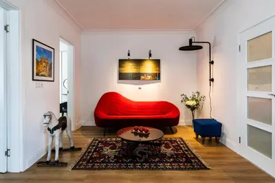 a living room with a red couch and a table at Aristocratic apartment with a parking spot in Sofia