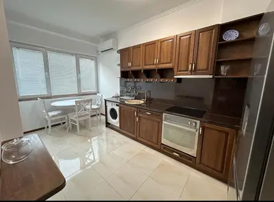 a kitchen with wooden cabinets and a table and a dining room at Apartament 88 in Sofia