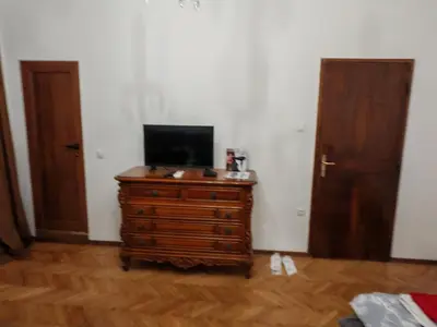 a room with a tv on a wooden dresser with two doors at Apartament 88 in Sofia