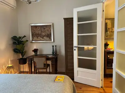 a bedroom with a door and a table and a desk at Laurel & Hardy - Old city center Apart in Sofia