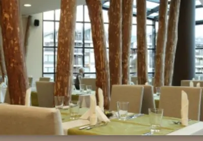 a dining room with tables and chairs and trees at Aspen Golf Resort and SPA, Studio J006 in Bansko