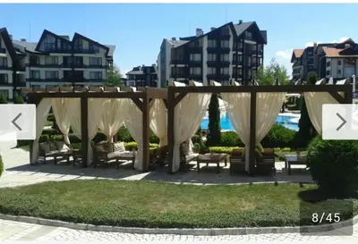 a pergola with chairs and tables in a park at Aspen Golf Resort and SPA, Studio J006 in Bansko