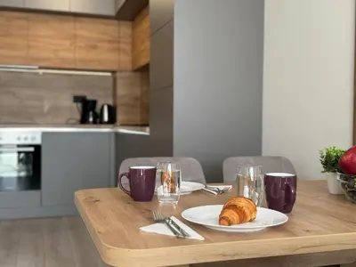a wooden table with a plate of croissants on it at Modern 1BR Apartment with Free Street Parking and free Gym Pass in Plovdiv