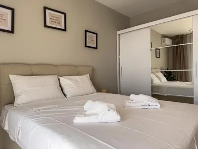 a white bed with two towels on top of it at Modern 1BR Apartment with Free Street Parking and free Gym Pass in Plovdiv