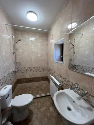 a bathroom with a toilet and a sink and a shower at Къща за гости Бадови in Hisarya