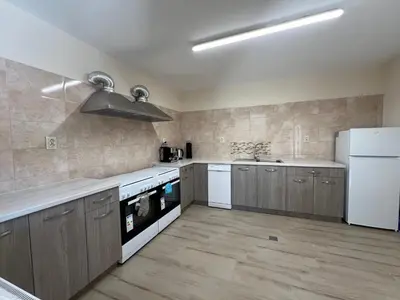 a kitchen with wooden cabinets and a white refrigerator at Къща за гости Бадови in Hisarya