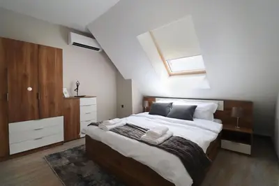 a bedroom with a large bed with a skylight at New Sofia Skyline 1BDRM Free Parking & Terrace in Sofia