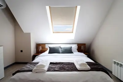 a bedroom with a bed with two pillows and a window at New Sofia Skyline 1BDRM Free Parking & Terrace in Sofia