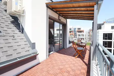a balcony with a wooden pergola and a table at New Sofia Skyline 1BDRM Free Parking & Terrace in Sofia