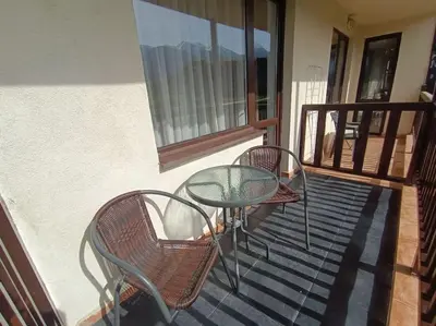 a glass table and chairs on a balcony at Студио в хотел Мария Антоанета in Bansko