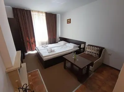 a small room with a bed and a table at Студио в хотел Мария Антоанета in Bansko