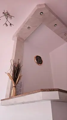 a fireplace with a clock on the top of it at Апартаменти за гости Кедър in Sapareva Banya