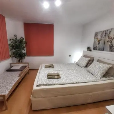 a bedroom with a large bed and a red wall at Garden apartment in Karlovo