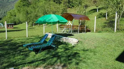 a couple of chairs and an umbrella and a table at Вила Идилия in Ribarica