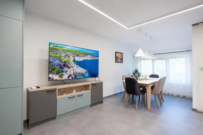 a living room with a table and a flat screen tv at Arni Aparts in Velingrad