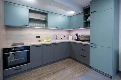a large kitchen with blue cabinets and appliances at Arni Aparts in Velingrad
