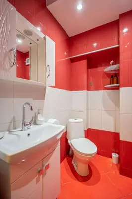 a red and white bathroom with a toilet and a sink at Pirotska 2-Bedroom 100m2 Apartment in Sofia Center in Sofia