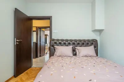 a bedroom with a large bed with pink pillows at Pirotska 2-Bedroom 100m2 Apartment in Sofia Center in Sofia