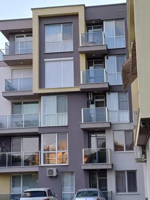 an apartment building with balconies and cars parked in front at Апартамент - Студио Престиж 3 in Hisarya