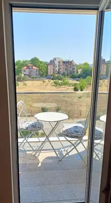 a patio with a table and two chairs on a balcony at Апартамент - Студио Престиж 3 in Hisarya