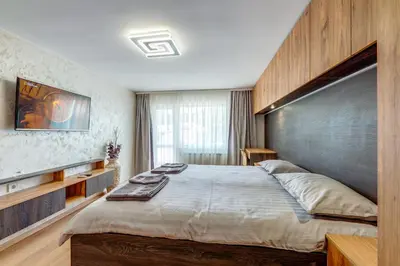 a bedroom with a large bed with a large wooden headboard at Rhodope Escape - Modern 1BR Apartment with Balcony & Free Parking in Smolyan