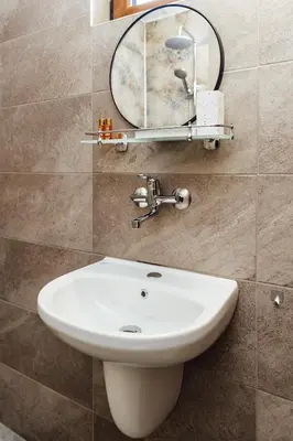 a bathroom with a white sink and a mirror at Къщи БРИК вила 2 in Sapareva Banya