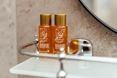 two bottles of honey sitting on a bathroom sink at Къщи БРИК вила 2 in Sapareva Banya