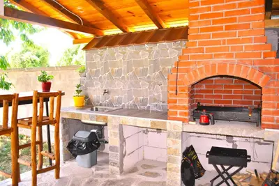 a outdoor kitchen with a brick pizza oven at Къщи БРИК вила 2 in Sapareva Banya