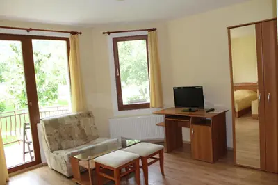 a living room with a chair and a desk with a television at By the River Hotel Complex in Balkanets