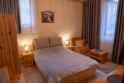 a bedroom with a bed and two lamps on tables at Костовският хан in Chepelare
