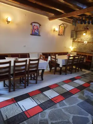 a restaurant with tables and chairs in a room at Костовският хан in Chepelare