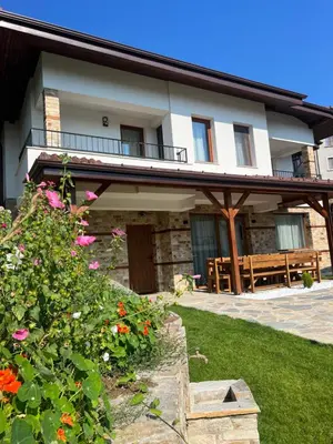 a house with a balcony and flowers in the yard at Spa Villas Daffi in Smolyan