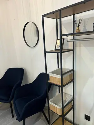 a black book shelf with two chairs and a mirror at Pirotska Cozy Room in Sofia