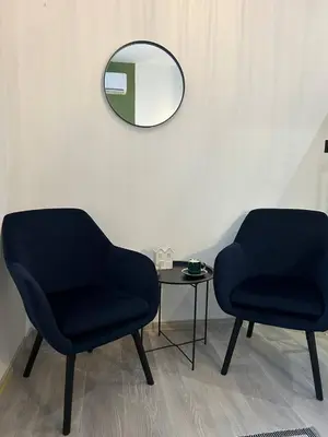 two chairs and a table in a room with a mirror at Pirotska Cozy Room in Sofia