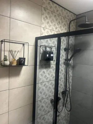 a shower with a glass door in a bathroom at Pirotska Cozy Room in Sofia
