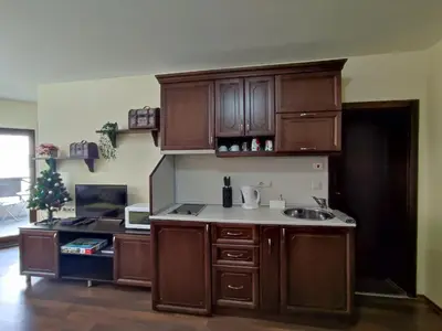 a kitchen with wooden cabinets and a sink at Aspen Apartment A212 3OOm from Gondola in Bansko