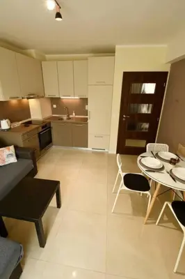 a kitchen and a living room with a table and chairs at INB Banishora Spot in Sofia