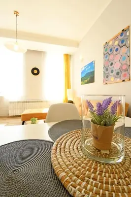 a table with a vase with purple flowers on it at Eagle's Spot in Sofia
