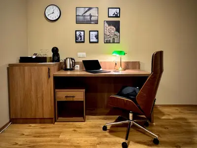 an office with a desk with a laptop and a chair at Apartments Sofia Airport free shuttle and parking in Sofia