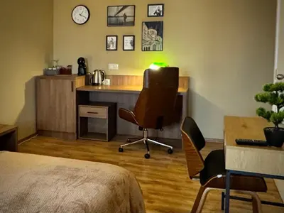 a bedroom with a desk with a chair and a table at Apartments Sofia Airport free shuttle and parking in Sofia