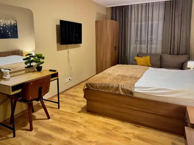 a bedroom with a bed and a desk and a television at Apartments Sofia Airport free shuttle and parking in Sofia