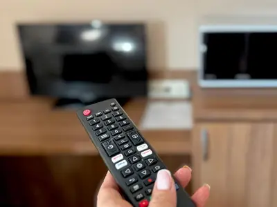 a person holding a remote control in a living room at Apartments Sofia Airport free shuttle and parking in Sofia